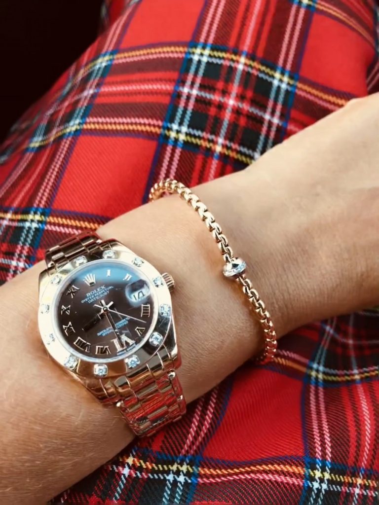 Rolex watch & FOPE bracelet on wrist, tartan dress