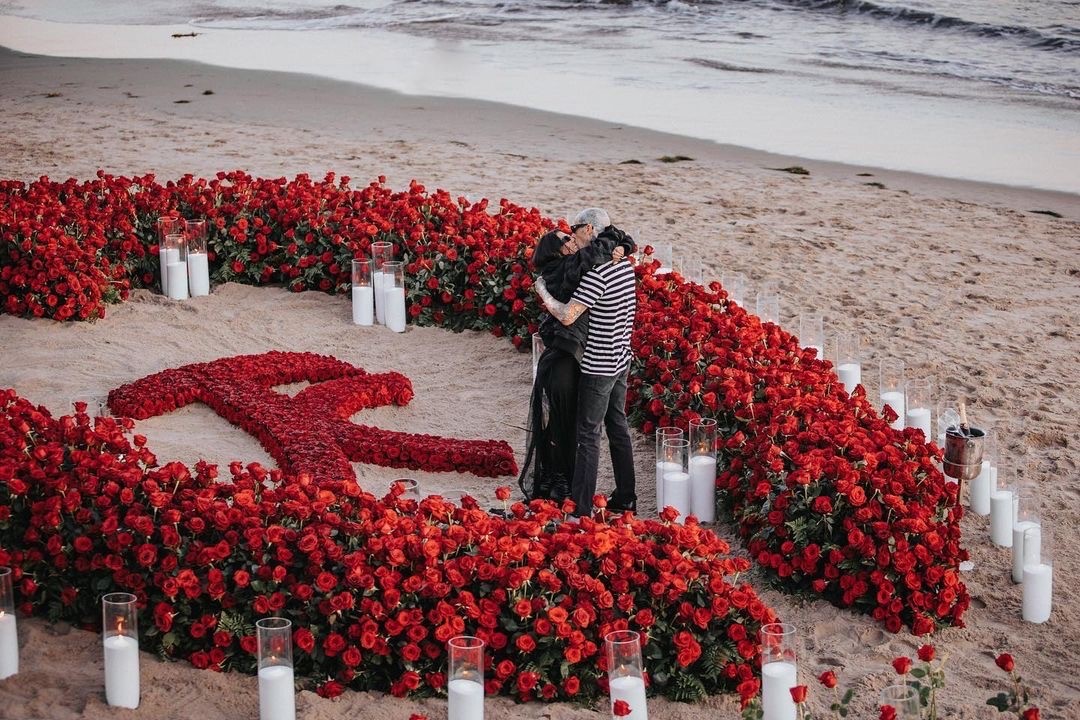 Kourtney Kardashian and Travis Barker proposal moment on beach with red roses 
