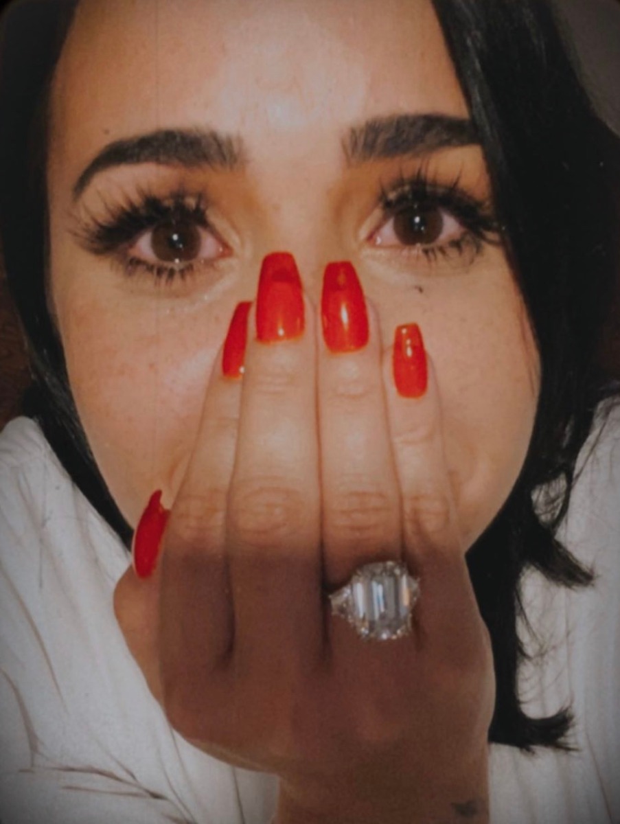 Close Up Emerald Three Stone Diamond Engagement Ring on Demi Lovato's Hand